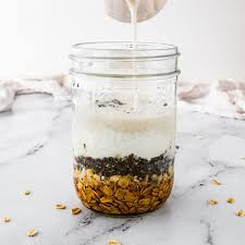 In a jar or container combine rolled oats milk Greek yogurt chia seeds honey vanilla extract and a pinch of salt